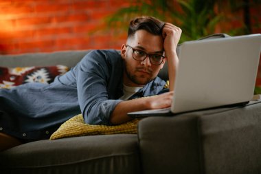 Evdeki dizüstü bilgisayarda dizi izleyen bir adam..