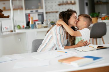 Güzel, genç bir anne çocuğuna ödevlerinde yardım ediyor..