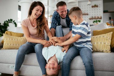 Genç bir aile evde eğleniyor. Mutlu ebeveynler ve çocuklar eğleniyor..