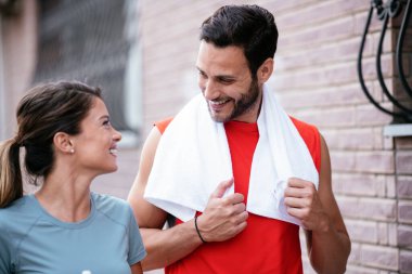 Atletik çift şehirde koştuktan sonra dinleniyor. Mutlu çift sabahları eğleniyor...