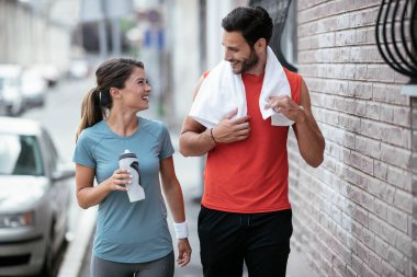 Atletik çift şehirde koştuktan sonra dinleniyor. Mutlu çift sabahları eğleniyor...