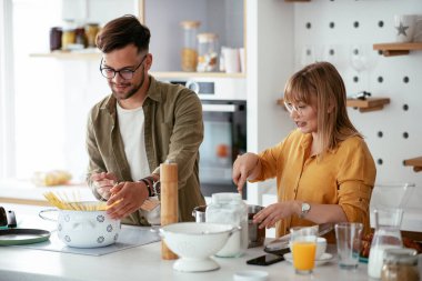 Karı koca mutfakta. Genç çift evde lezzetli yemekler hazırlıyor..