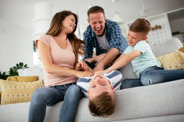 Genç bir aile evde eğleniyor. Mutlu ebeveynler ve çocuklar eğleniyor..