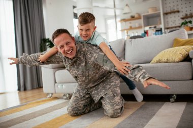 Askerler evlerinde oğluyla oynuyorlar. 