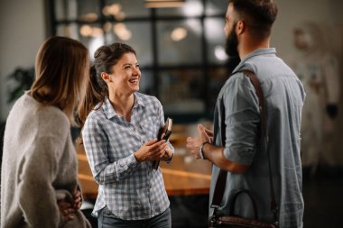 Modern açık uzay ofisinde sıradan iş adamlarından oluşan bir grup. İş kadınları ve işadamları yeni proje hakkında konuşuyor.