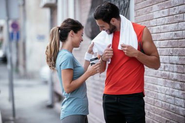 Atletik çift şehirde koştuktan sonra dinleniyor. Mutlu çift sabahları eğleniyor...