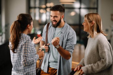 Modern açık uzay ofisinde sıradan iş adamlarından oluşan bir grup. İş kadınları ve işadamları yeni proje hakkında konuşuyor.