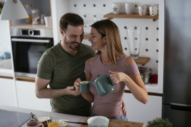 Mutlu çift mutfakta kahvaltı yapıyor. 