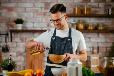 Güzel bir kadın yemek pişiriyor ve mutfakta eğleniyor. Kız mutfakta sağlıklı yemek pişiriyor..