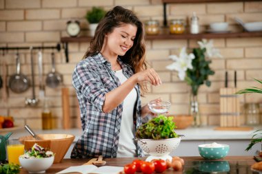 Mutfakta yemek yapan güzel genç bir kadının portresi. Genç Kadın Aşçılık. Sağlıklı Yemek - Sebze Salatası.
