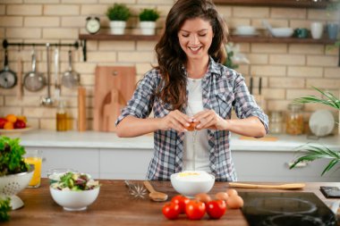 Mutfakta yemek yapan güzel genç bir kadının portresi. Genç Kadın Aşçılık. Sağlıklı Yemek - Sebze Salatası.