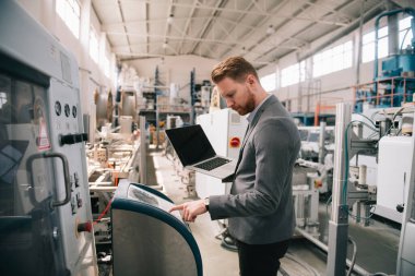 Fabrika müdürü imalat teftişinde. Endüstriyel çevredeki adam.