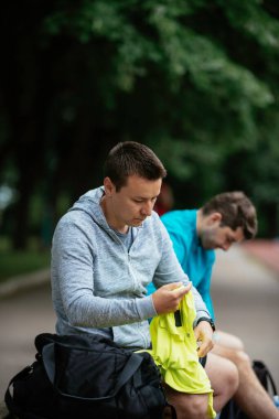 Koşmaktan istirahat eden zinde genç adamlar. Dışarıda antrenman yapan iki arkadaş..