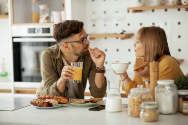 Genç çift evde lezzetli yemekler yapıyor. Sevgi dolu çift mutfakta eğleniyor..