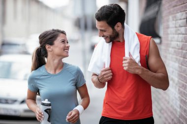Atletik çift şehirde koştuktan sonra dinleniyor. Mutlu çift sabahları eğleniyor...