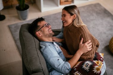 Genç ve sevgi dolu bir çift kanepede dinleniyor. Mutlu çift evde eğleniyor..