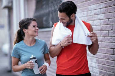 Atletik çift şehirde koştuktan sonra dinleniyor. Mutlu çift sabahları eğleniyor...