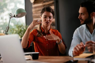 Ofisteki meslektaşlar. İş kadını ve işadamı ofiste iş tartışıyorlar. İki arkadaş birlikte çalışıyor..
