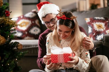 Evde Noel hediyesiyle kız arkadaşına sürpriz yapan genç adam..