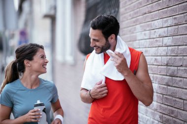 Atletik çift şehirde koştuktan sonra dinleniyor. Mutlu çift sabahları eğleniyor...