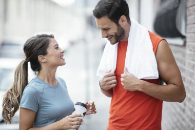 Atletik çift şehirde koştuktan sonra dinleniyor. Mutlu çift sabahları eğleniyor...
