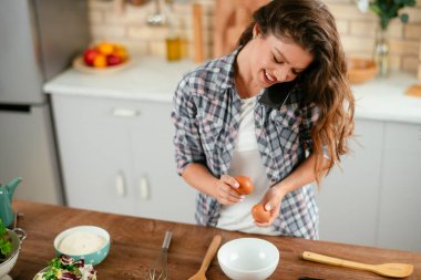 Mutfakta yemek yapan güzel genç bir kadının portresi. Genç Kadın Aşçılık. Sağlıklı Yemek - Sebze Salatası.