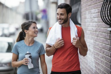 Atletik çift şehirde koştuktan sonra dinleniyor. Mutlu çift sabahları eğleniyor...