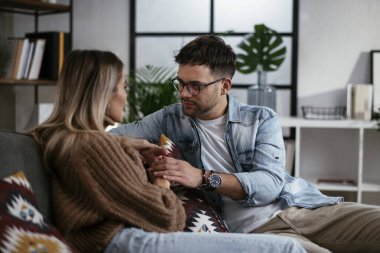 Evde oturan ve konuşan genç bir çift. Sevgili çift randevuda..