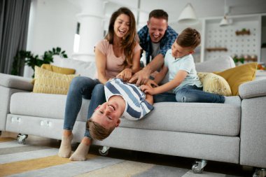 Mutlu aile kanepede birlikte vakit geçiriyor. 