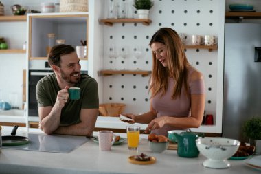 Mutlu çift mutfakta kahvaltı yapıyor. 