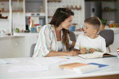 Anne oğluyla ödev yapıyor.