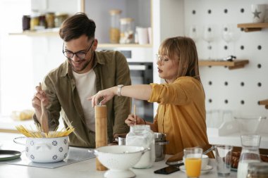 Karı koca mutfakta. Genç çift evde lezzetli yemekler hazırlıyor..
