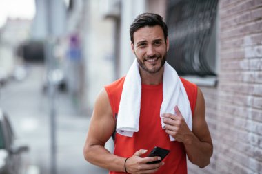 Genç sporcu dışarıda koşuyor. Açık hava eğitiminden sonra yakışıklı bir adam dinleniyor..