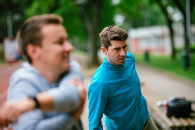 Yarış pistinde egzersiz yapan genç adamlar. Dışarıda antrenman yapan iki genç arkadaş..