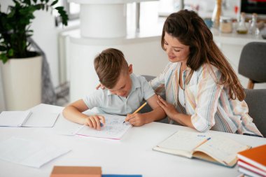 Anne oğluyla ödev yapıyor.