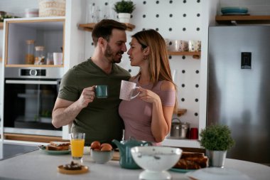 Mutlu çift mutfakta kahvaltı yapıyor. 