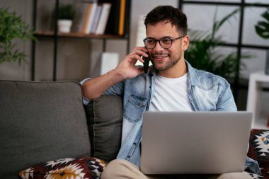 Adam evde çalışıyor, dizüstü bilgisayar kullanıyor.