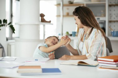 Anne oğluyla ödev yapıyor.