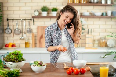 Mutfakta yemek yapan güzel genç bir kadının portresi. Genç Kadın Aşçılık. Sağlıklı Yemek - Sebze Salatası.