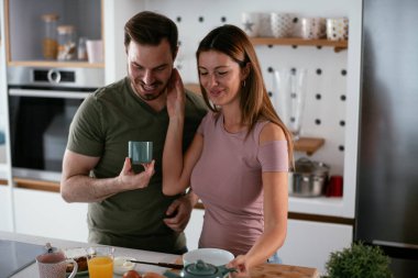 Mutlu çift mutfakta kahvaltı yapıyor. 