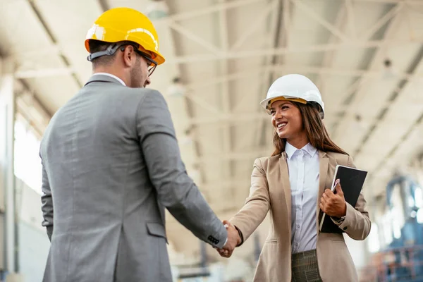 Erkek ve kadın mimarlar fabrikada buluşuyor. 