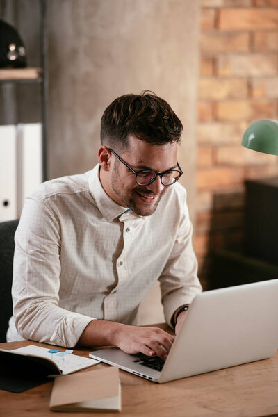 Businessman working in the office on his laptop. Stylish businessman working on a project in the office.