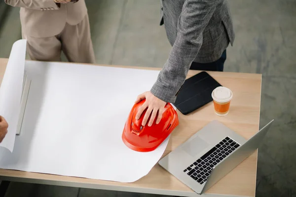 İnşaat malzemeleri. Miğfer ve planlar masanın üstünde..