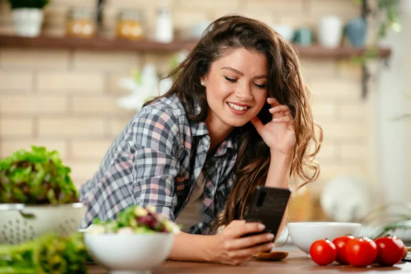 Food blogger using smartphone taking photo. Young woman photographing food in the kitchen.