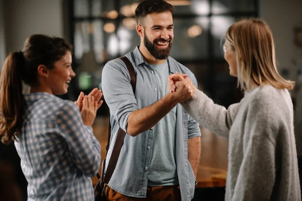 Modern açık uzay ofisinde sıradan iş adamlarından oluşan bir grup. İş kadınları ve işadamları yeni proje hakkında konuşuyor.