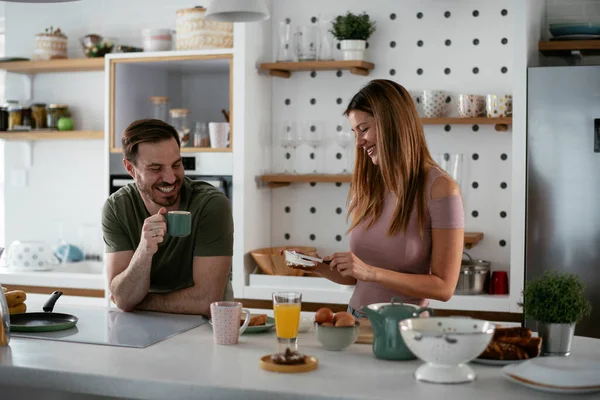Mutlu çift mutfakta kahvaltı yapıyor. 