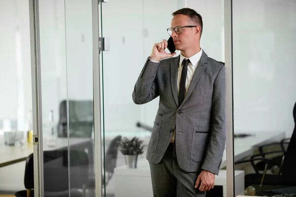 Businessman discussing work on phone. Young businessman talking on the phone at the office.