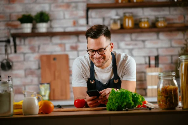 Mutfakta makarna hazırlayan yakışıklı adam. Lezzetli yemek pişiren adam..