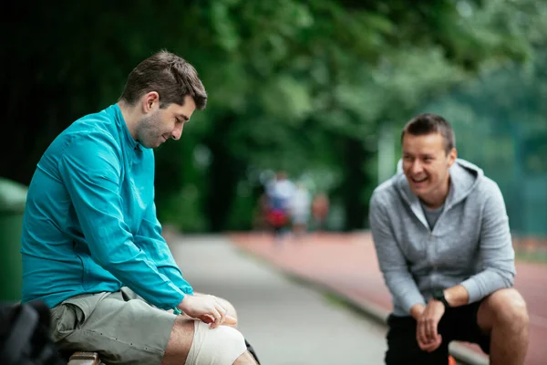 Koşmaktan istirahat eden zinde genç adamlar. Dışarıda antrenman yapan iki arkadaş..