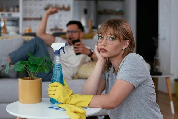 Young tired woman cleaning home. Young beautiful woman at home.